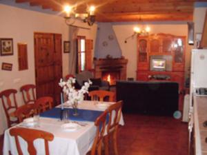 una sala da pranzo con tavolo e fiori di House 6 Bedrooms with Pool and WiFi 8798 ad Almáchar