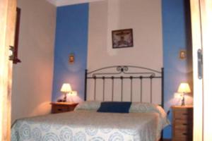 una camera da letto con un letto con pareti blu e due lampade di House 6 Bedrooms with Pool and WiFi 8798 ad Almáchar