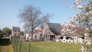 uma casa velha com uma cerca e uma árvore em Natuurschoon Vakantiewoning Moorsel em Moorsel