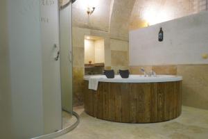 a bathroom with a wooden tub and a sink at Ürgüp Inn Cave Hotel in Urgup