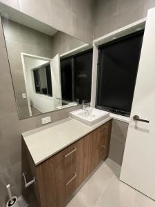 W łazience znajduje się umywalka i lustro. w obiekcie Comfortable 2 Story Villa next to a Canal w mieście Gold Coast