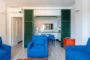 a living room with blue chairs and a kitchen at ALTIDO Apt in the Heart of Portofino, with Lovely View in Portofino