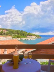 twee glazen wijn op een tafel met uitzicht op de oceaan bij Villa Marga in Jelsa