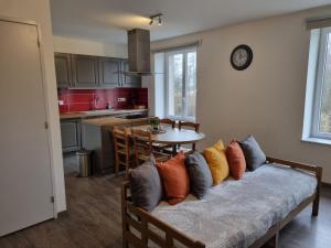 - un canapé avec des oreillers dans la cuisine dans l'établissement Au beau séjour, à Mayet-de-Montagne