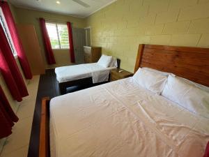 a bedroom with two beds in a room at Keris Rental Houses in Vaitele