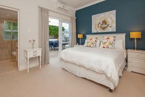 a bedroom with a large white bed and blue walls at Wild Waters at Kraal Rock on the cliffs in Hermanus in Hermanus