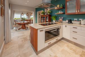 a kitchen with an island with a stove top oven at Wild Waters at Kraal Rock on the cliffs in Hermanus in Hermanus