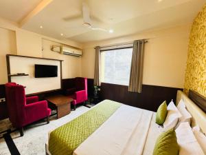 um quarto de hotel com uma cama e uma televisão em Hotel The Leaf - Gomti Nagar Lucknow em Lucknow