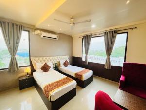 a hotel room with two beds and windows at Hotel The Leaf - Gomti Nagar Lucknow in Lucknow