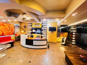 a lobby with a waiting room with a couch and a table at Hotel The Leaf - Gomti Nagar Lucknow in Lucknow