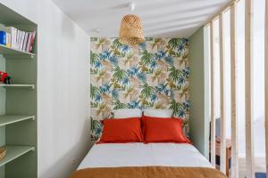 una camera da letto con un letto con cuscini rossi di STUDIO COSY NEUF ORSAY - Proche ecoles et entreprises a Orsay