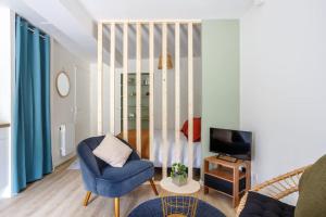 a living room with a blue chair and a television at STUDIO COSY NEUF ORSAY - Proche ecoles et entreprises in Orsay