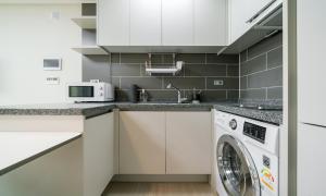 a kitchen with a washer and a washing machine at Urbanstay Songdo Moonlight Park in Incheon