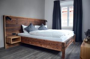 a bedroom with a large bed with a wooden headboard at Genusswerk Krug SB Hotel in Bad Endorf