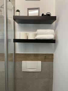 a bathroom with black shelves and white towels at Genusswerk Krug SB Hotel in Bad Endorf