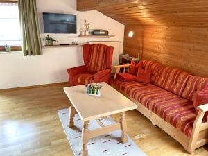 a living room with a couch and a table at Ferienwohnung Bauernhaus Kailhof in Aschau im Chiemgau