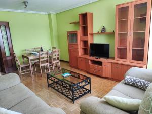 uma sala de estar com um sofá e uma mesa em Vivienda vacacional cuatrocaminos em Berrón