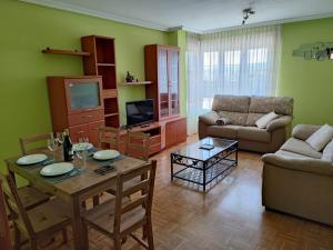 uma sala de estar com uma mesa e um sofá em Vivienda vacacional cuatrocaminos em Berrón