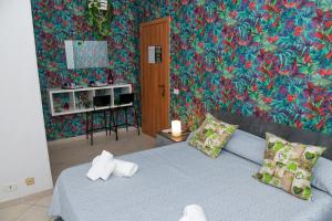 サンタ・マリア・ディ・カステッラバーテにあるB&B Damianiのカラフルな壁のベッドルーム1室(青いベッド1台付)