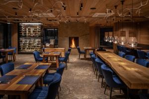 a restaurant with wooden tables and chairs and a fireplace at Aldrov Resort in Vítkovice