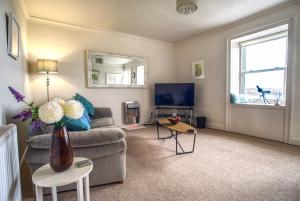 ein Wohnzimmer mit einem Sofa und einem TV in der Unterkunft The View in Garlieston