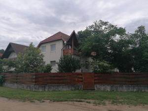 una casa detrás de una valla de madera en Sarkifény Vendégház, en Vásárosnamény
