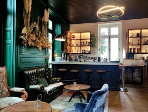 a bar with green walls and a table and chairs at Domaine de La Gressière in La Bernerie-en-Retz