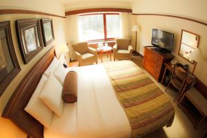 a hotel room with a large bed and a television at Alyeska Resort in Girdwood