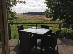 un tavolo e sedie su una terrazza con vista su un campo di Ferienhaus Anja a Glowe