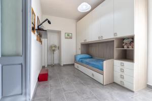 1 dormitorio con cama con sábanas azules y taburete rojo en Domus Sedini vacanze al mare, en Sedini