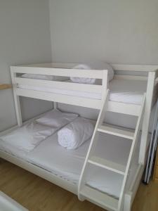 a bunk bed with white bunk beds in a room at Santhooft B , bus 514 Nieuwpoort bad in Nieuwpoort