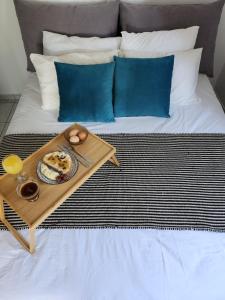 - un plateau de nourriture sur un lit avec une table dans l'établissement Serenita verde Apartment, à Poros