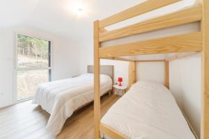 拉維西爾的住宿－Le Pajot - Appt pour 6 proche pistes，一间卧室设有两张双层床和一扇窗户。