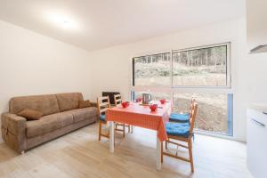 拉維西爾的住宿－Le Pajot - Appt pour 6 proche pistes，客厅配有桌子和沙发