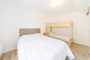 - une chambre avec un grand lit blanc et une échelle dans l'établissement Le Pajot - Appt pour 6 proche pistes, à Laveissière