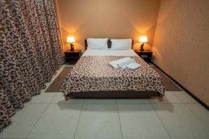 タシュケントにあるRohat Hotel Chilonzorのベッドルーム1室(ベッド1台、タオル2枚付)