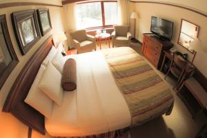 a bedroom with a large bed and a television at Alyeska Resort in Girdwood