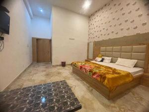 - une chambre avec un grand lit dans l'établissement OYO Vaikunth Radhika Farm, à Govardhan