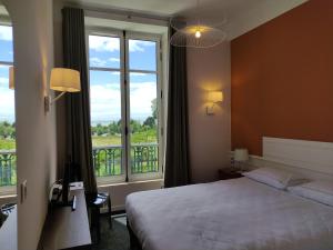 ラ・ベルヌリー・アン・レッツにあるDomaine de La Gressièreのベッドと大きな窓が備わるホテルルームです。