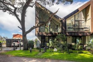 a house with a tree in front of it at Forest Cottage in Palanga
