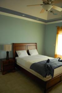1 dormitorio con 1 cama y ventilador de techo en Casa del Sol Tobago en Bon Accord Village