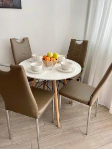 a white table with chairs and a bowl of fruit on it at Adria Sky in Rijeka