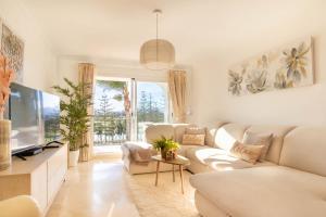 uma sala de estar com um sofá branco e uma televisão em Fairway Apartman Mijas Golf 1 - Golondrinas em Mijas