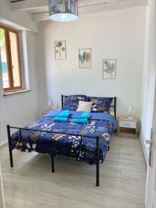 a bedroom with a bed with blue pillows on it at Les orchidées in Saint-Cybranet