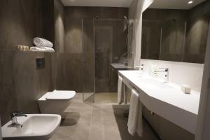 uma casa de banho com 2 lavatórios, um chuveiro e um WC. em Hotel Bodega FyA - GRUPO PIÉROLA em Navarrete