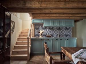 a kitchen with blue cabinets and a staircase at Alkis Farm and Residence in Yírion