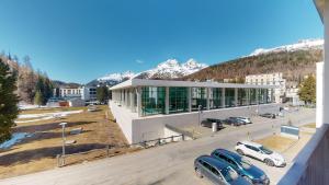 um grande edifício com carros estacionados num parque de estacionamento em Abitaziun Ova Cotschna 3B - St Moritz em St. Moritz