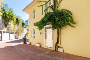 un edificio amarillo con una puerta y un árbol al lado de una calle en Gold City Luxury Accommodation, en Kargicak