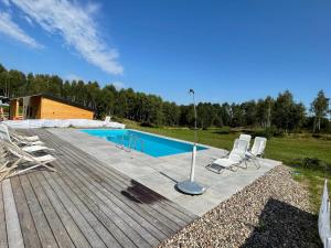 a deck with chairs and a swimming pool at Brzozowisko Tuchomko - Glamping in Tuchomie