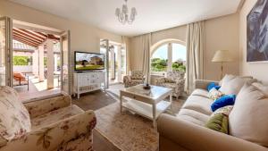 een woonkamer met een bank en een tv bij Villa Luxoria Ema in Čabrunići